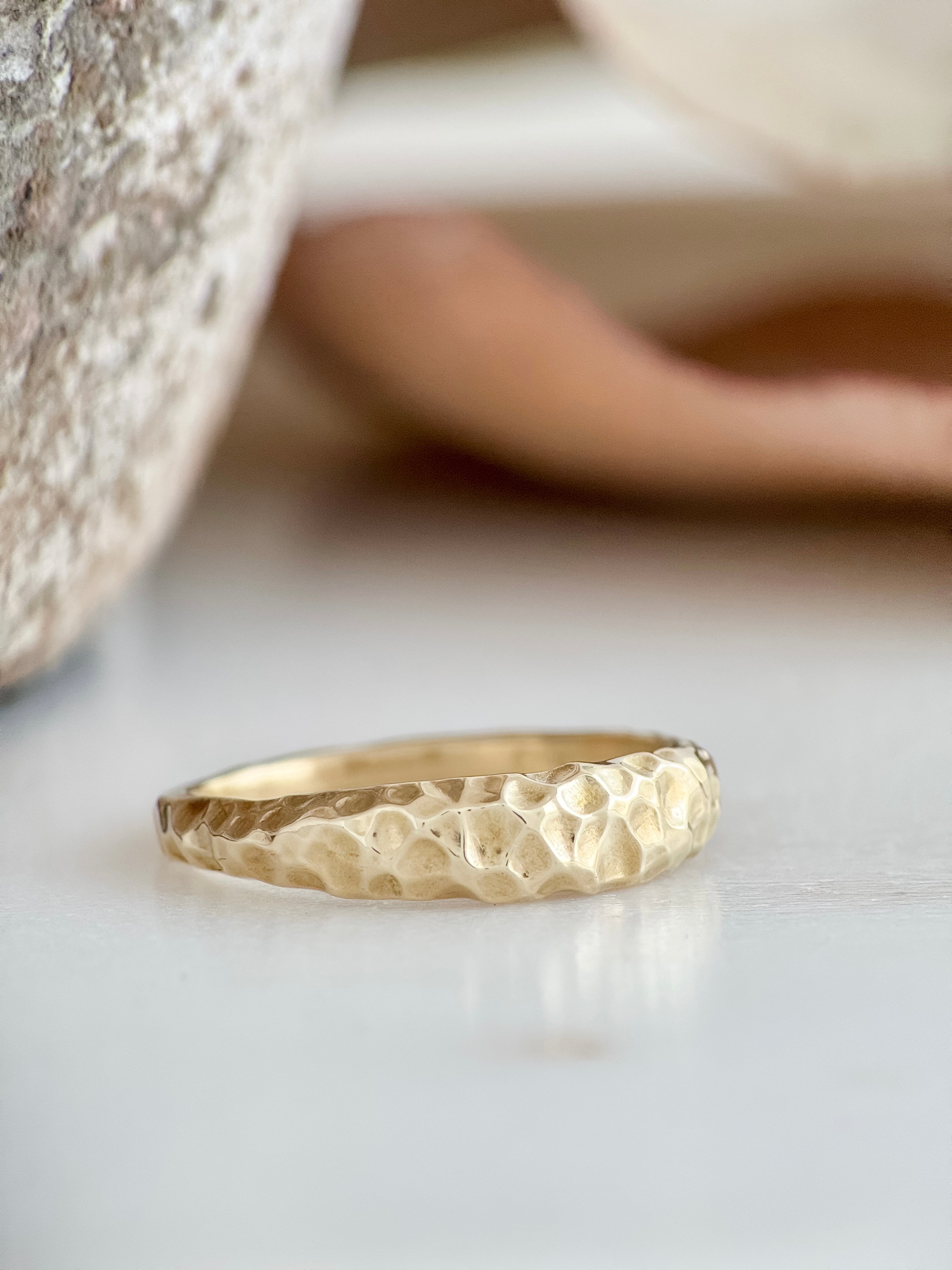 Gold ring with a textured surface on a light background