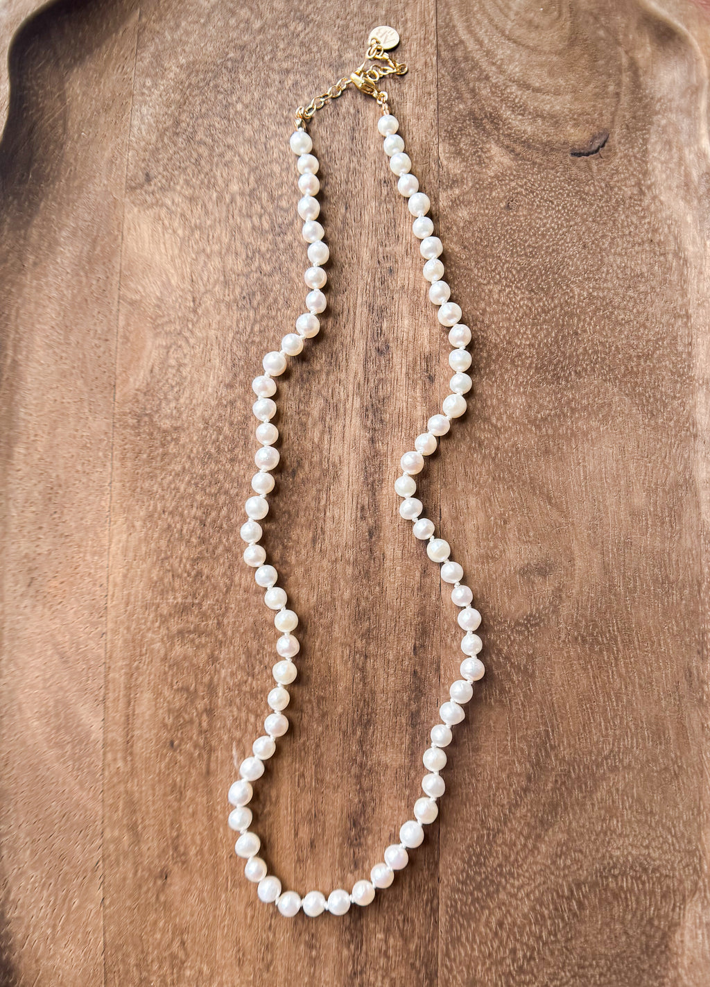 Pearl necklace on a wooden surface