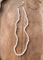 Pearl necklace on a wooden surface