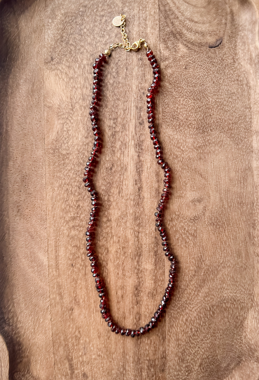 Garnet beaded necklace on a wooden surface