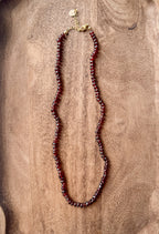 Garnet beaded necklace on a wooden surface