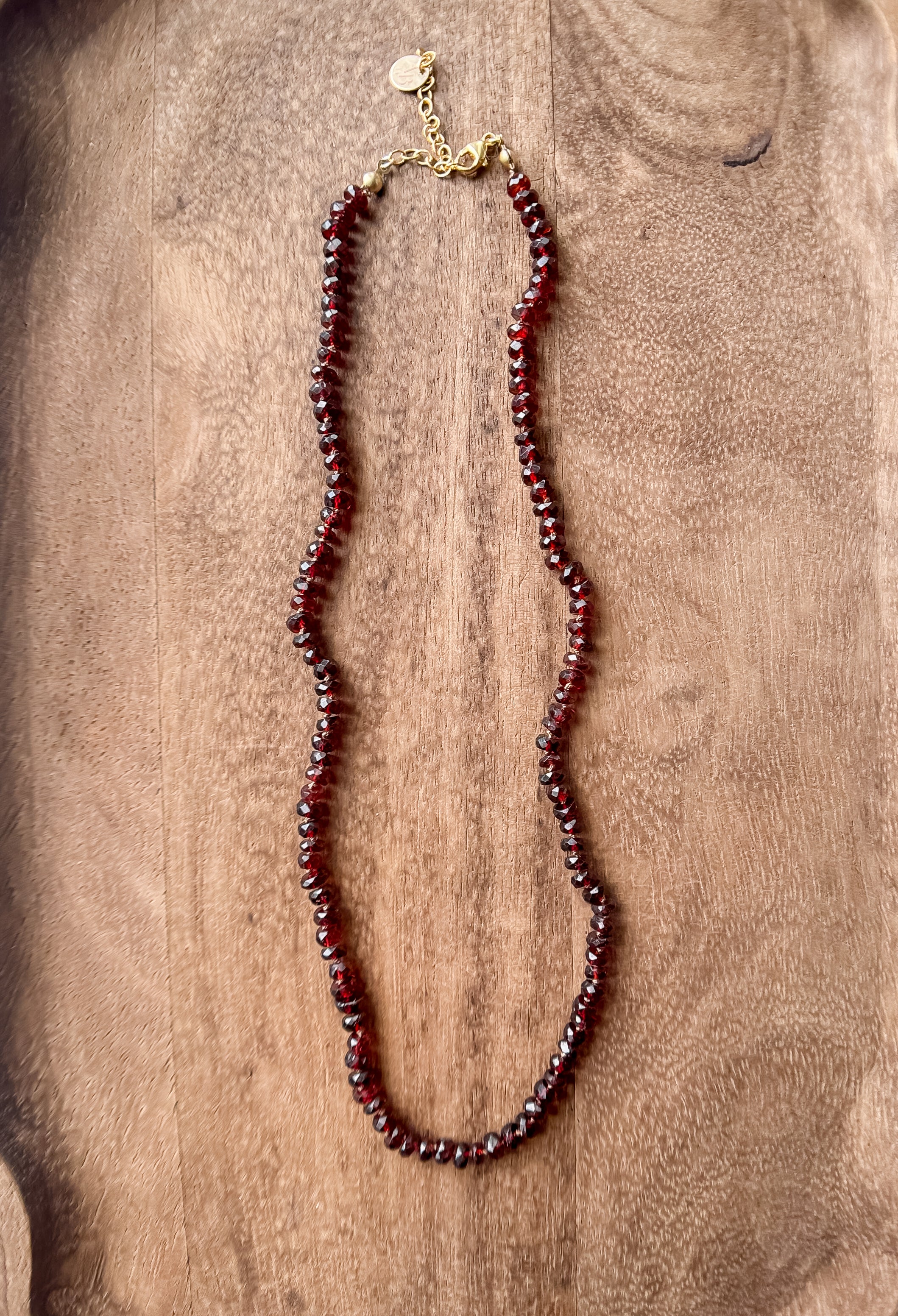 Garnet beaded necklace on a wooden surface