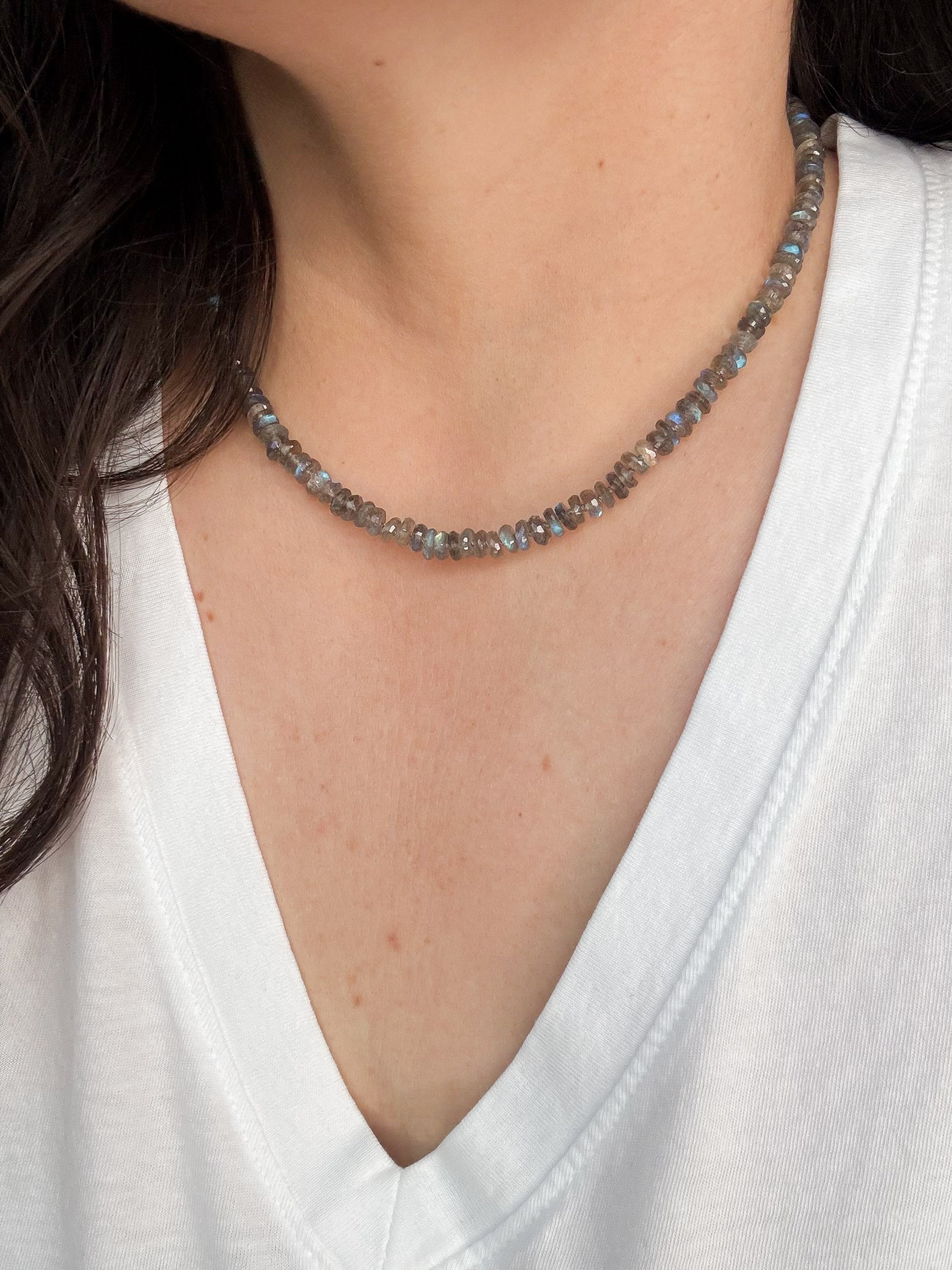 Necklace with 7-8 millimeter labradorite beads worn by a person in a white shirt