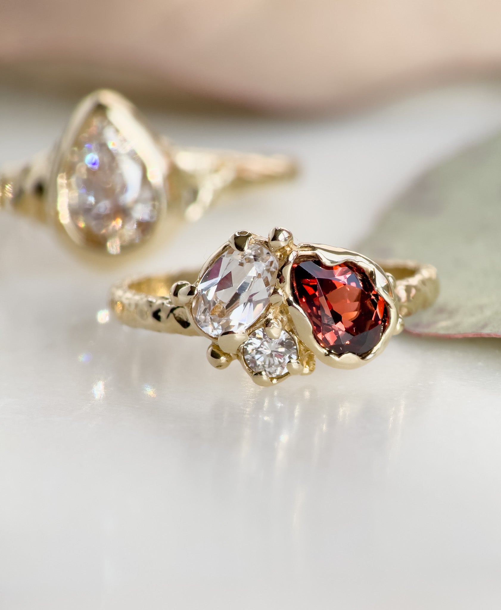 Gold ring with three gemstones on a light background