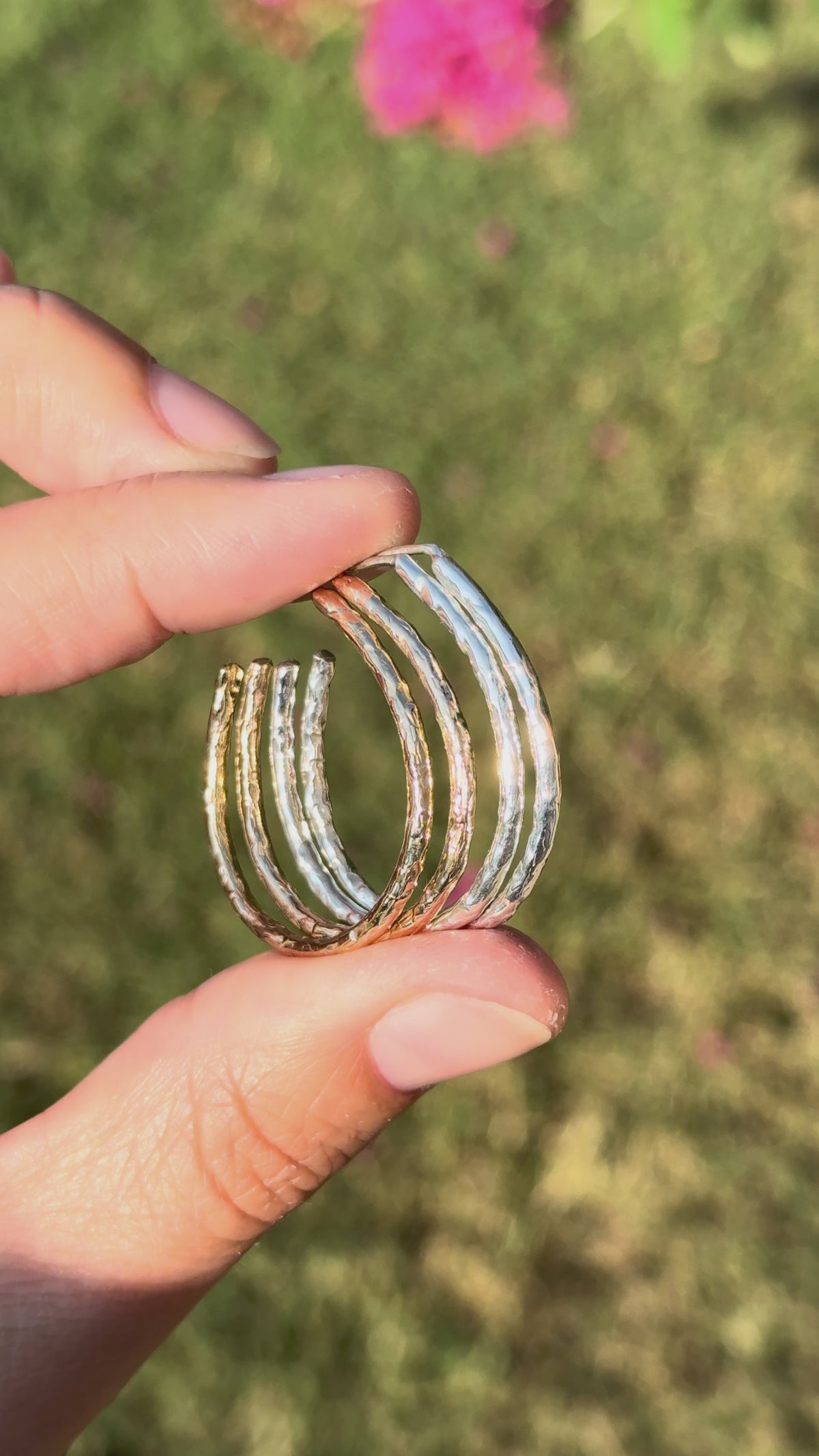 Sunlight sparkling off the texture of the Aura earring in solid gold and sterling silver.